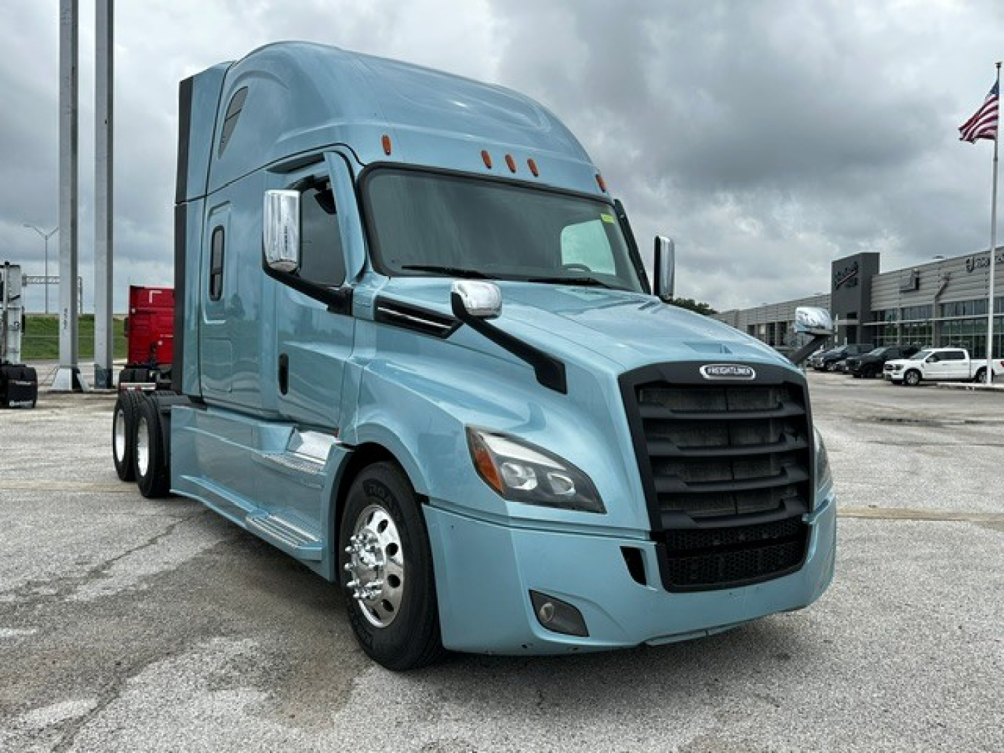 Freightliner Cascadia 126 truck in blue viewed from front-left, with large black grille and sleeper cab.