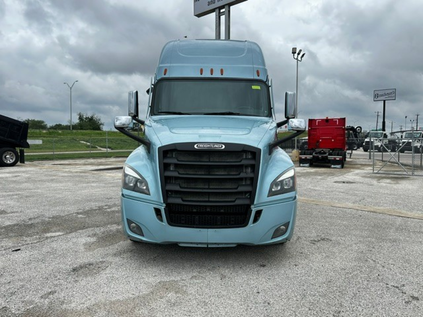 Freightliner Cascadia 126 truck front view in blue with black grille and aerodynamic mirrors.