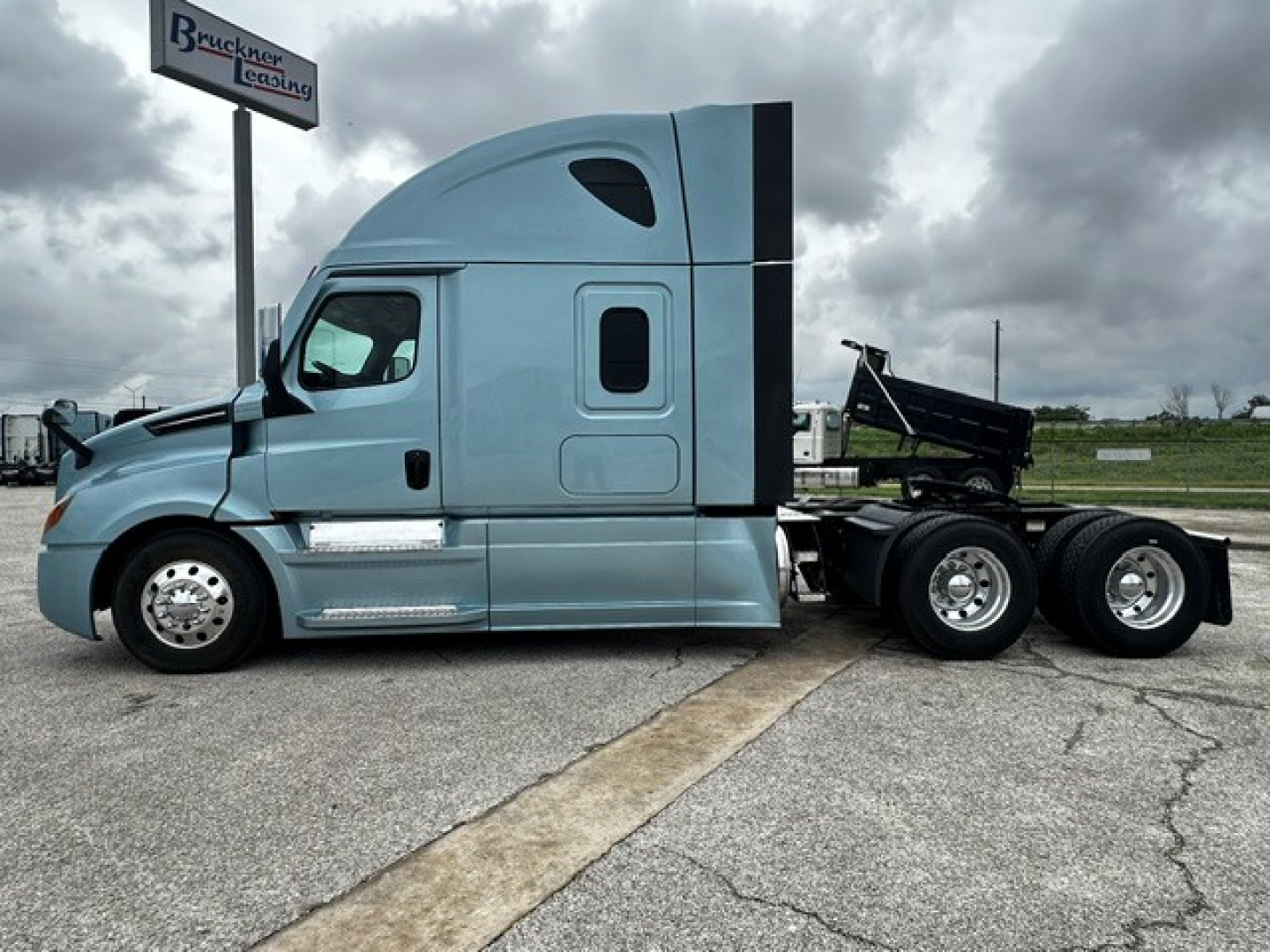 Freightliner Cascadia 126 sleeper cab in view from side show VIN plate area and fuel tanks.