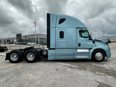 Side view of a light blue Freightliner Cascadia 126 tractor, showing the cab and tandem rear axles; no legible text visible on decals or badges due to image resolution.