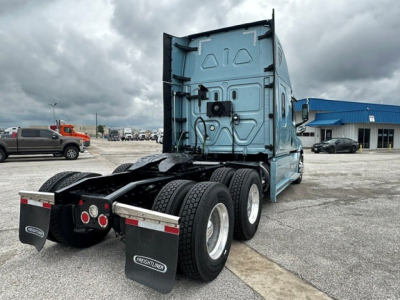 Freightliner Cascadia 126 tractor rear view showing dual rear axles, mud flaps with Freightliner logo, and sleeper cab