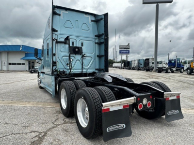 Truck rear view of a Freightliner Cascadia 126 tractor showing dual rear axles and mud flaps with Freightliner branding.