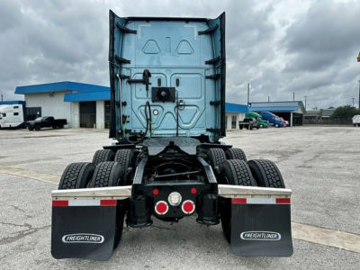 Freightliner Cascadia 126 tractor rear view showing dual rear axles, mud flaps with Freightliner logos, and rear chassis with fifth-wheel area.