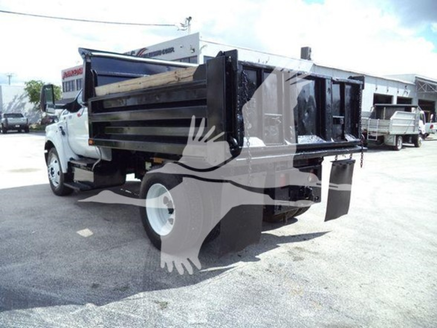 Dump truck bed on a used 2017 Ford F650 showing the rear dump bed and tailgate in a dealership lot.
