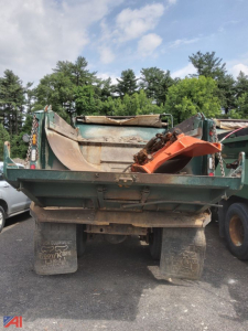 Dump truck bed of a 2010 Mack Granite Dump Truck with plows visible from rear view.