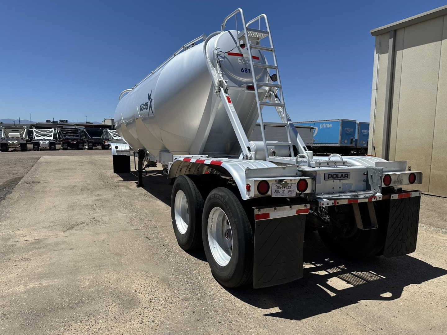 Pneumatic dry bulk trailer rear view showing Polar logo, dual-axle wheels, rear lights, and ladder.