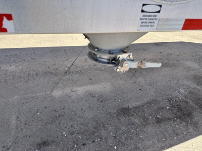 Trailer hitch and landing gear of a 2012 Polar 1000 cu ft gravity drop pneumatic air ride 3-hop trailer showing the underside with support kingpin and latch.