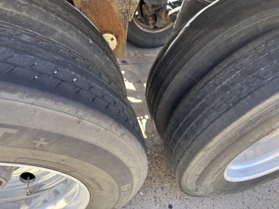 Trailer wheel area showing two large pneumatic tires and rims, with rusted frame behind; part of a Polar gravity drop pneumatic trailer.