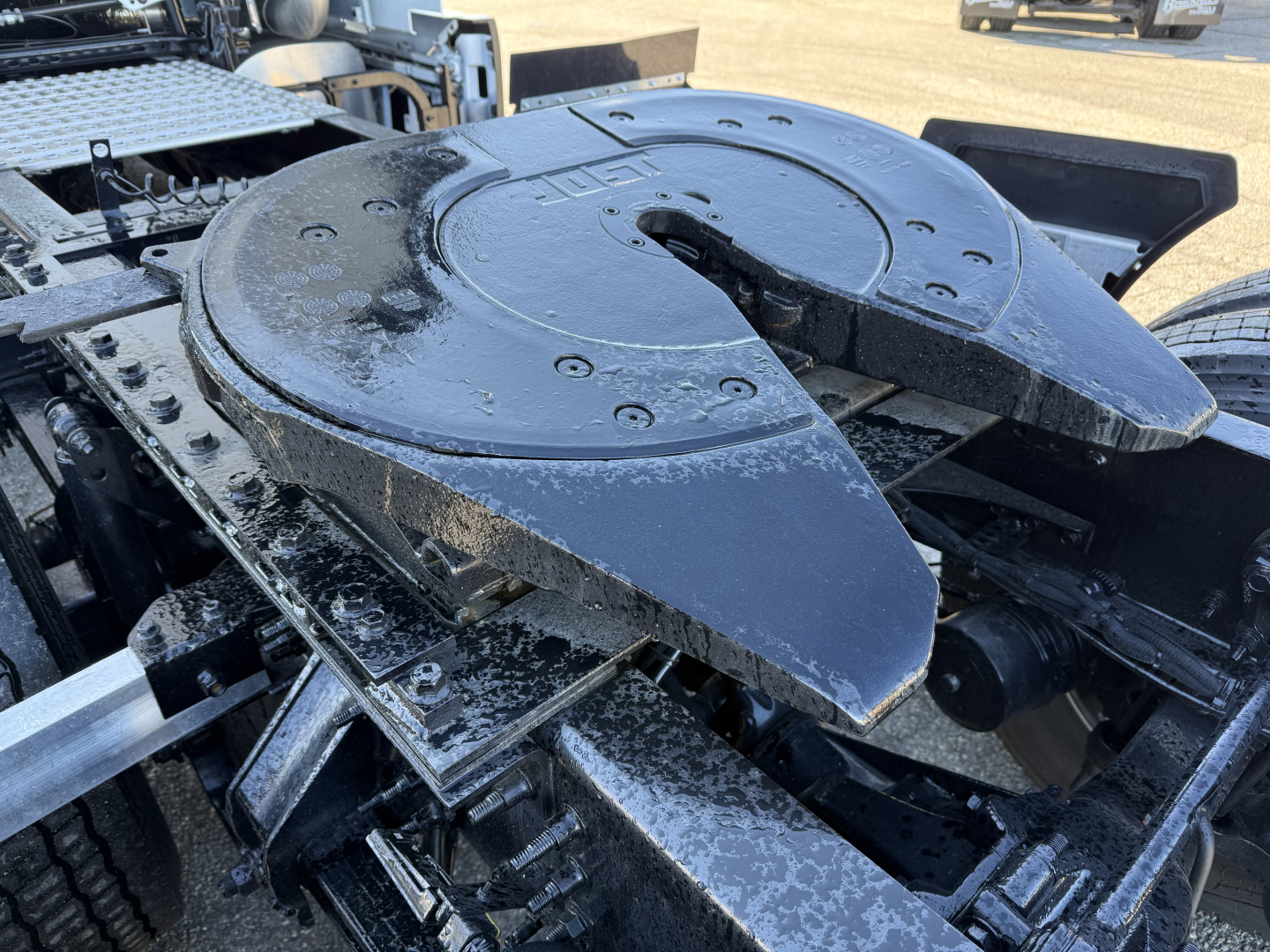 Volvo VNL64T860 tractor unit showing a circular main power take-off or accessory plate with surrounding components and surface grime.