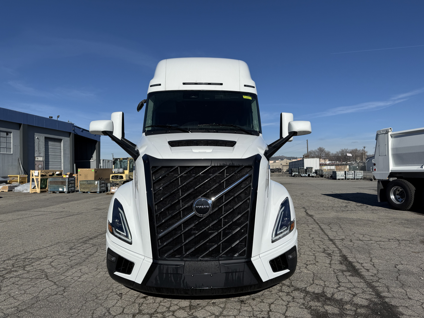 Volvo VNL64T860 truck front view showing bold grille, large headlights, side mirrors, and white cab.