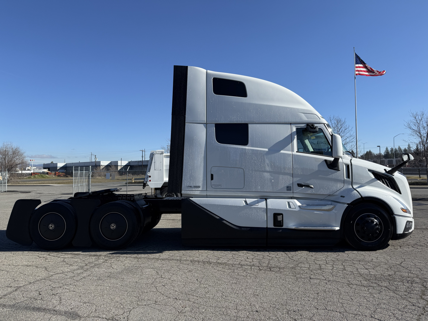 Volvo VNL64T860 truck side profile showing sleeper cab and chassis with flag in background
