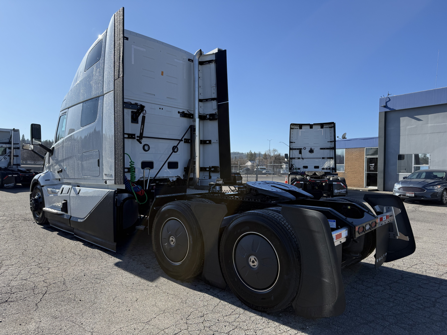Volvo VNL64T860 tractor cab rear and dual rear axles with attached fifth wheel and aerodynamic side fairings.