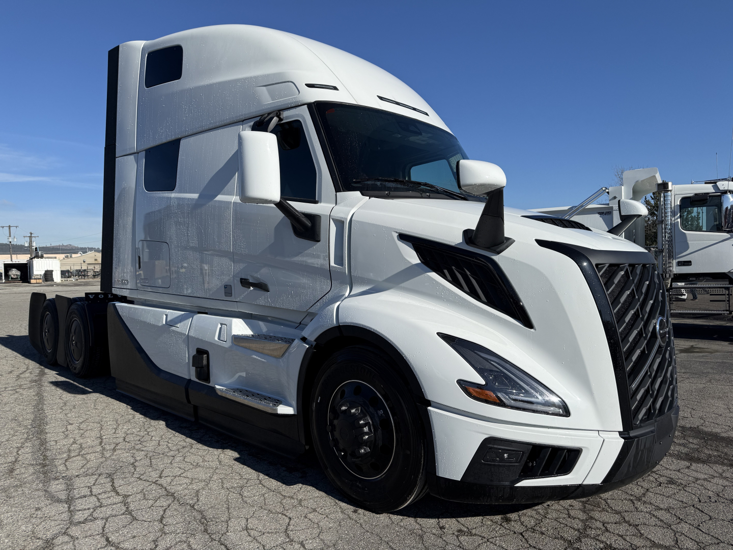 Volvo VNL64T860 truck in white exterior, front-left view showing aerodynamic hood and grille with sleeper cab