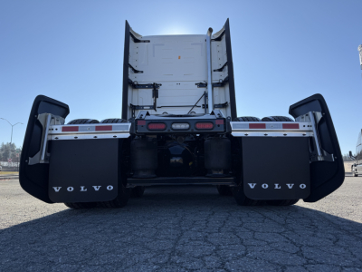 Volvo VNL64T860 rear view showing dual rear wheels, mud flaps with Volvo logo, and flatbed/tractor configuration.