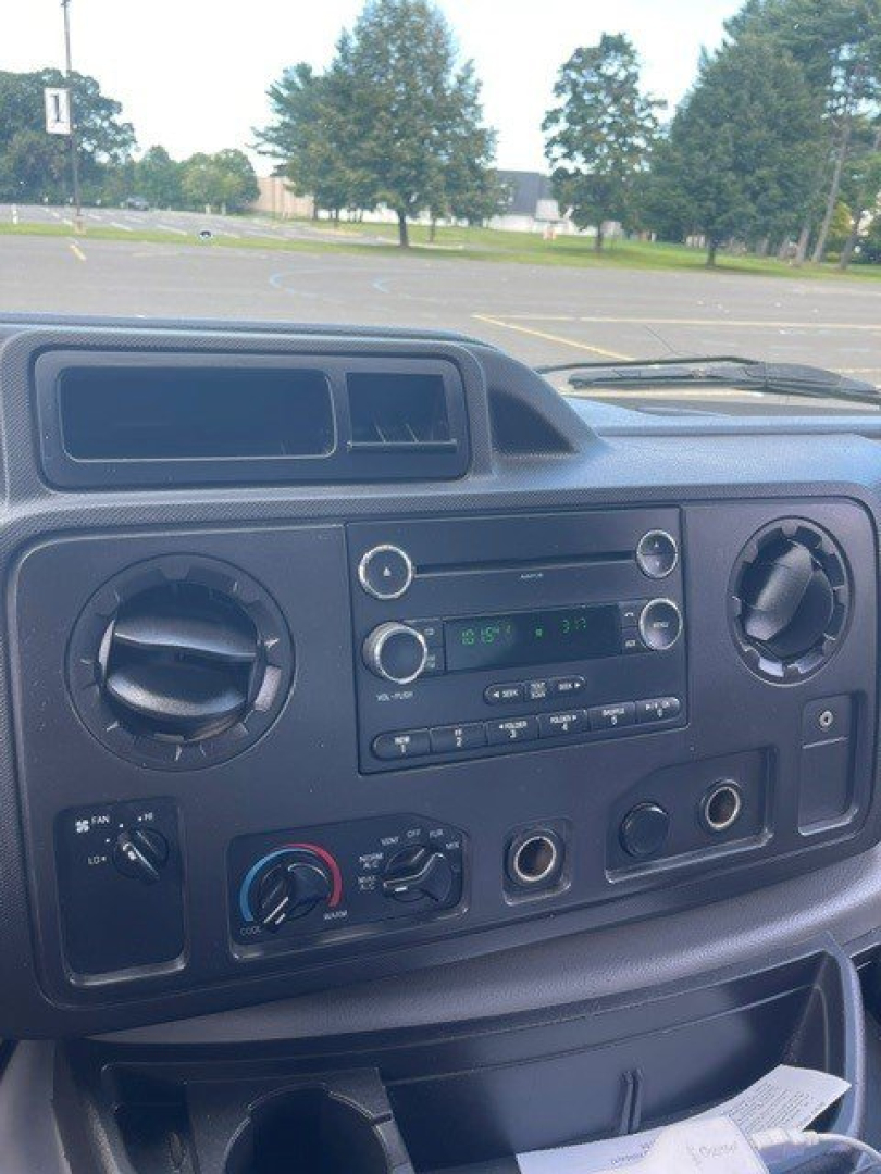Dashboard of a 2019 Ford E-Series Cutaway showing circular HVAC vents, radio, and climate controls.