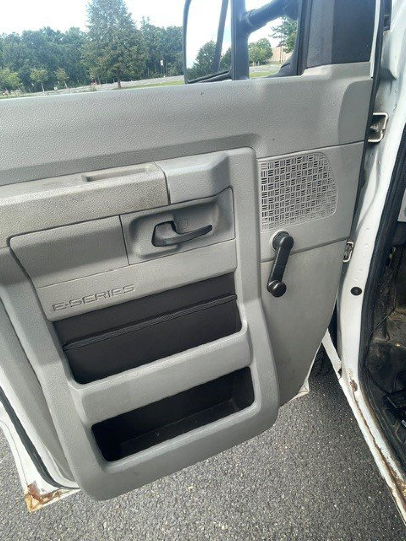 Ford E-Series Cutaway door panel showing manual window crank, storage pockets, and S-Series badge on the interior door, along with vent grid.