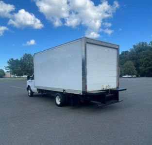 Truck cab chassis with a large white box cargo area on a Ford E-Series Cutaway, rear garbage-style ramp and black rear bumper.