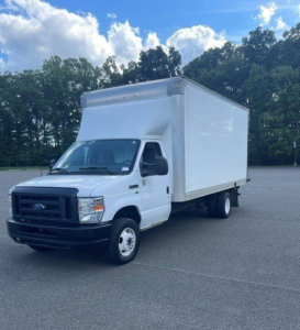 Truck cab chassis with box on back showing a white Ford E-Series Cutaway cargo body in a parking lot.
