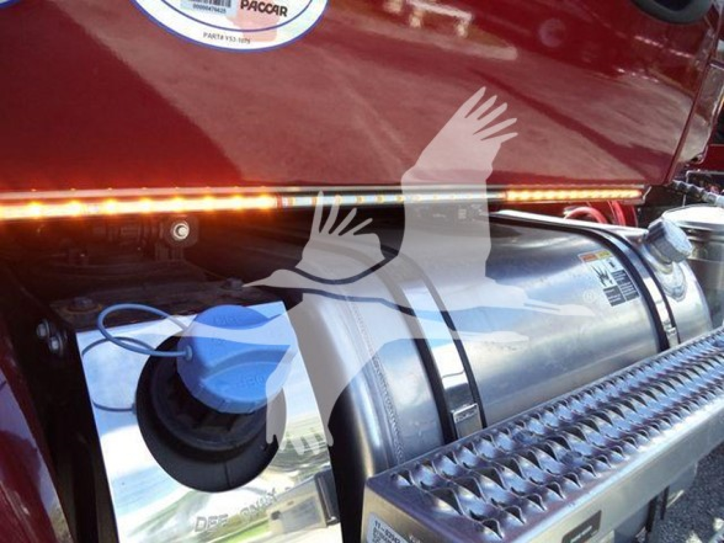 Kenworth engine bay showing DEF/Diesel exhaust fluid or fuel tank cap and step surface with chrome trim.