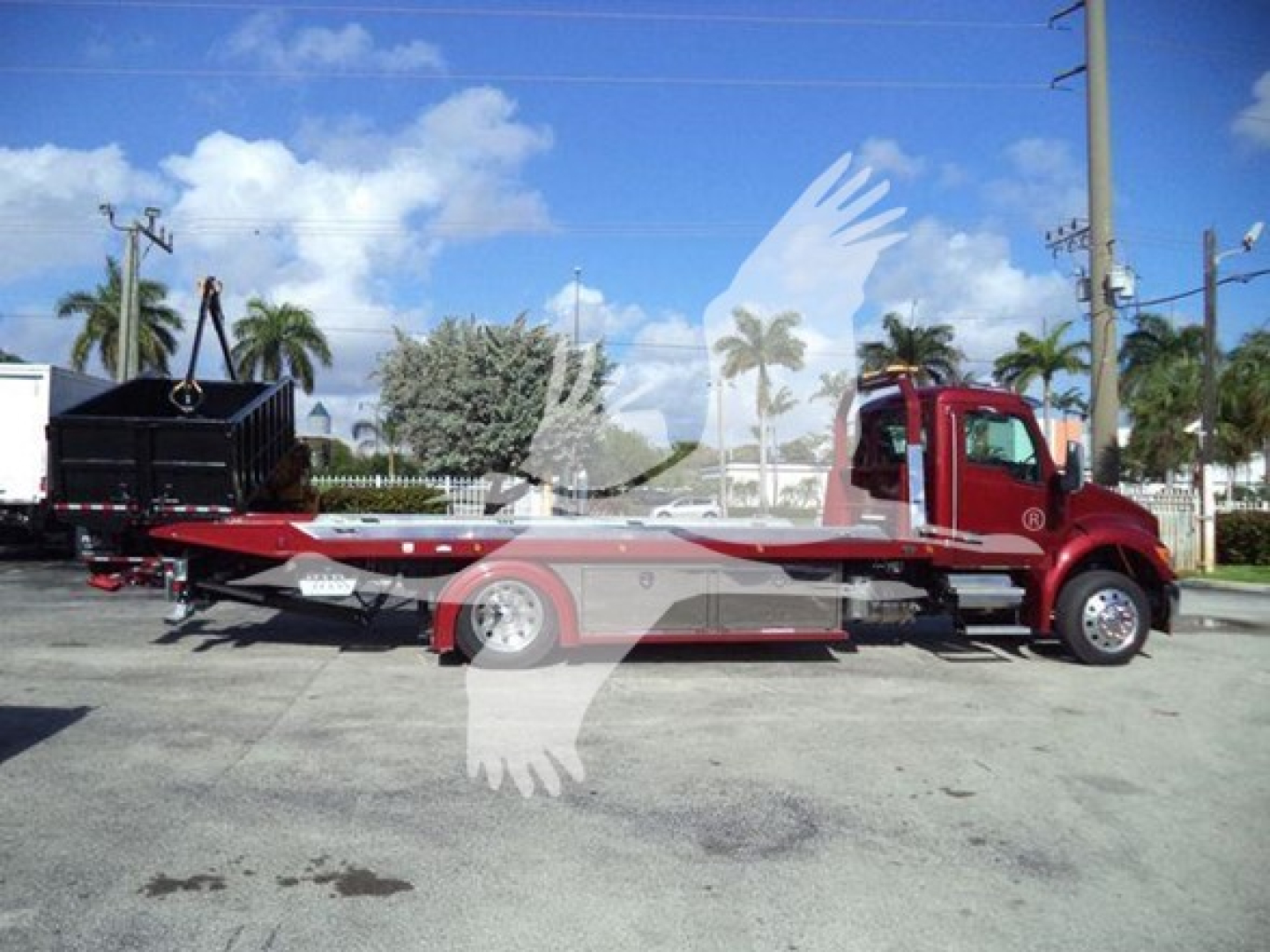 Kenworth T280 tow truck side view showing flatbed carrier and cab in red with long wheelbase.