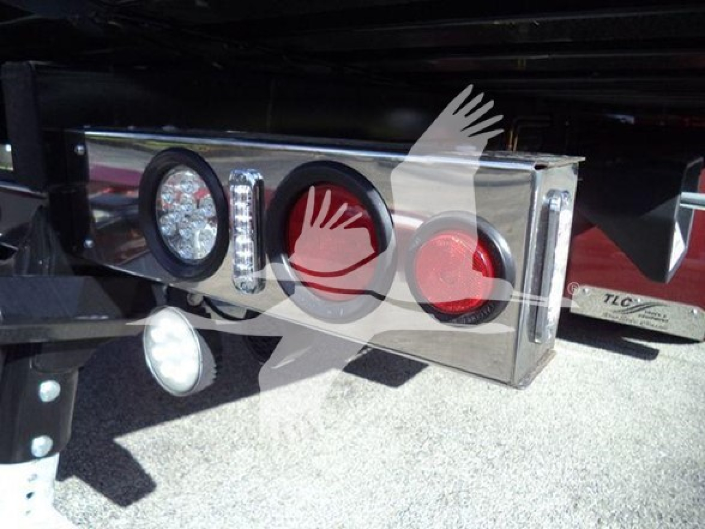 Truck rear taillights and bumper with chrome finish; visible circular lights and reflective surfaces under a hitch area.