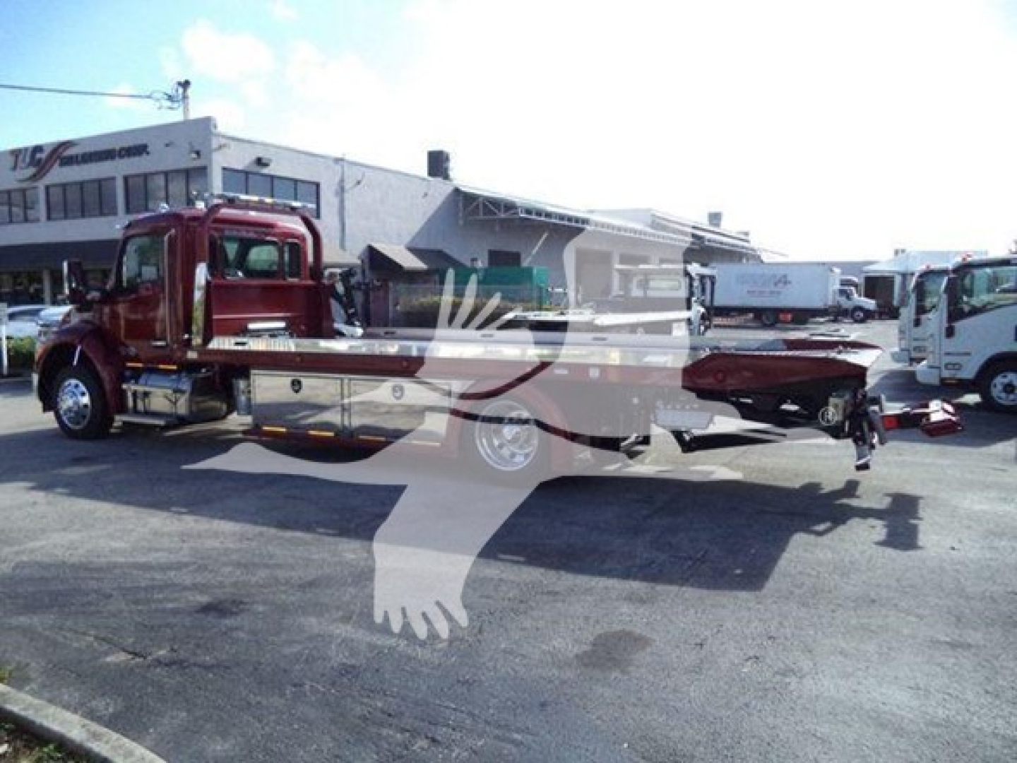 Kenworth T280 rollback truck in a dealership lot showing a red cab and flatbed tow body with a white overlay logo.