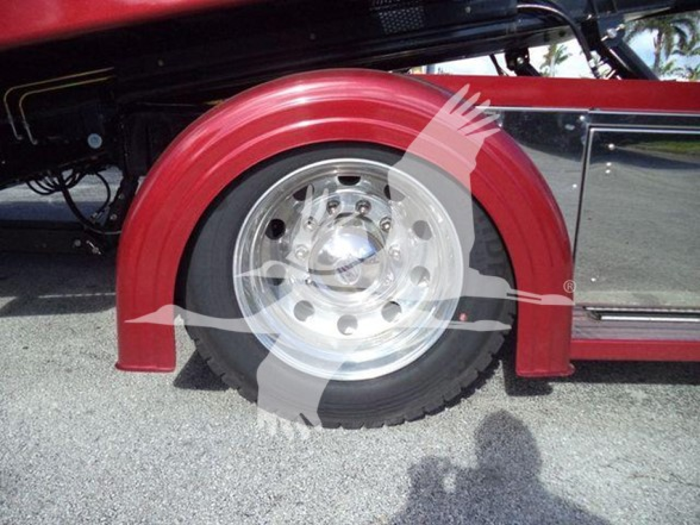 Kenworth truck rollback wheel well with red fender and silver hubcap showing wheel and tire