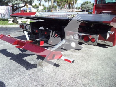 Kenworth rollback flatbed truck rear showing tailboard and hydraulic alignment guides with red tow arms and dual rear lights.