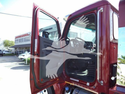 Truck cab open door showing interior of a red 2025 Kenworth T280 rollback truck.