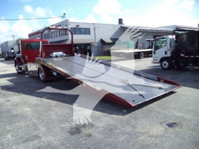 Kenworth T280 rollback truck with a flatbed in a lot; winch and ramps visible.