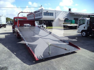 Kenworth T280 rollback bed with loading ramp and tractor in background.