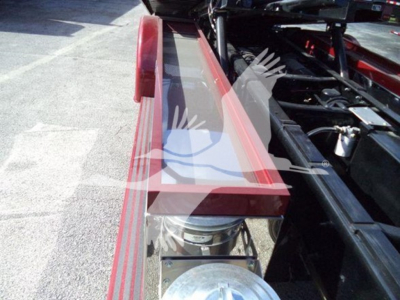 Kenworth T280 rollback truck chassis showing a red rectangular tool or bumper area and exposed mechanical components near the wheel well.