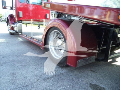 Kenworth T280 rollback truck side view showing rear wheel, red paint, chrome wheel, and loading equipment undercarriage.
