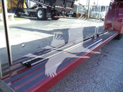 Rear view of a red rollback truck showing a reflective surface with a logo of a bird and text overlays; no legible model text visible.
