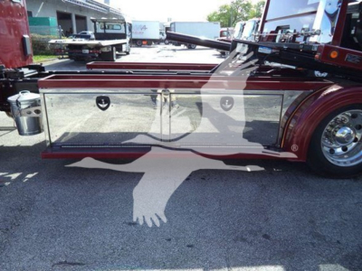 Kenworth T280 rollback truck side view showing chrome diamond plate storage compartments and toolbox along the frame with wheel and body reflectors.