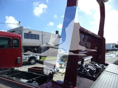 Kenworth T280 rollback truck bed and hydraulic system components visible in sunlit lot.