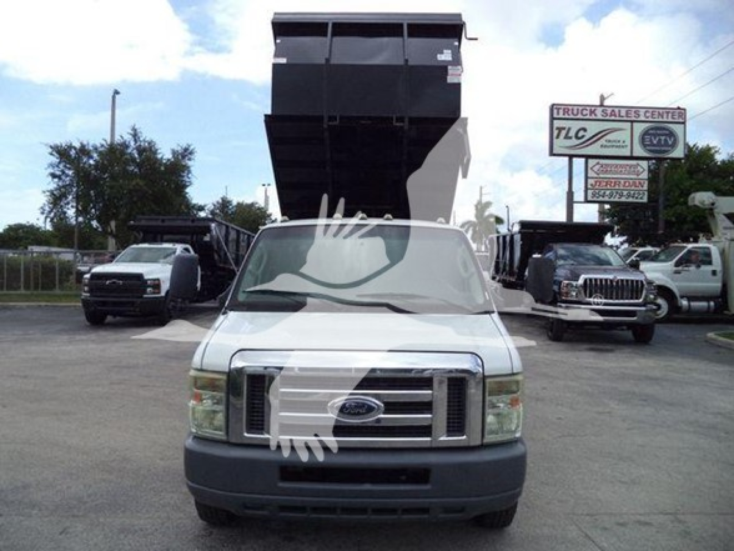 Ford E-450 cargo/dump truck front view with raised dump bed. Visible text on signs: TLC Truck Sales Center, VIN 1FDXE4FS1BDA83803 on listing not on vehicle.