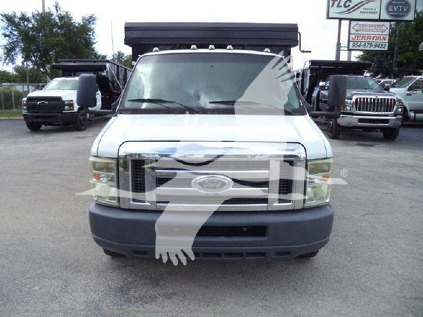 Front view of a white 2011 Ford E-450 dump truck with grille, bumper, and front lights visible.
