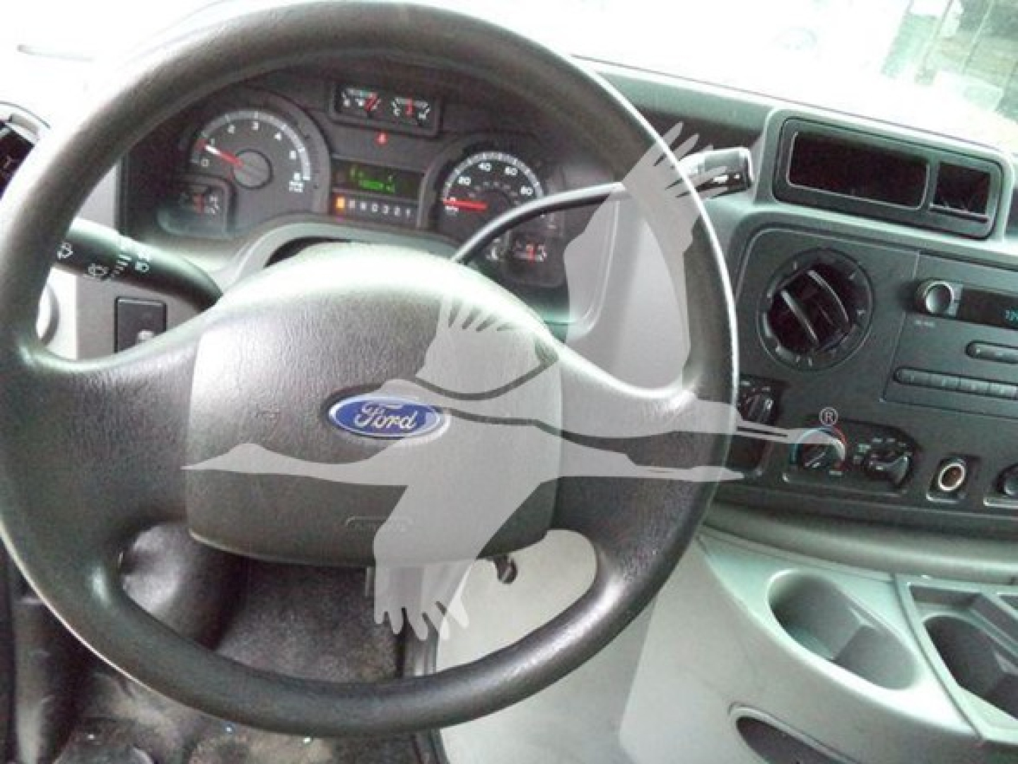 Ford E450 dash and steering wheel showing instrument cluster and center console with climate controls.