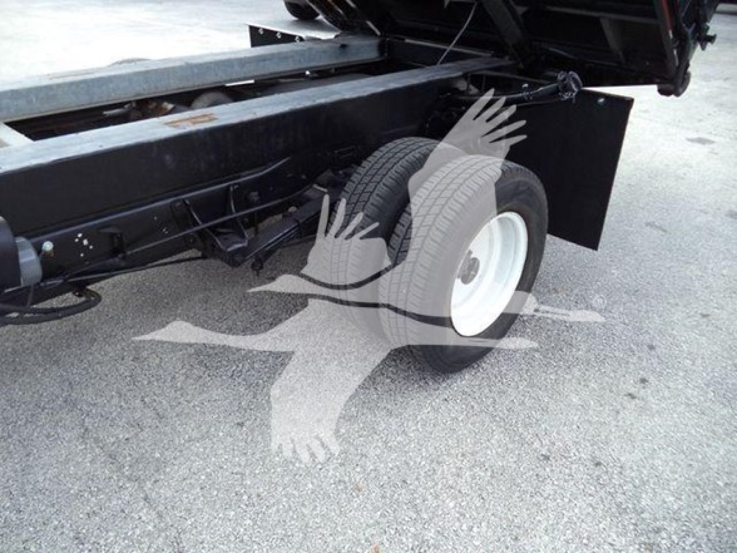 Ford E-450 dump truck rear chassis and single rear wheel visible; no specific labeling text readable on components.