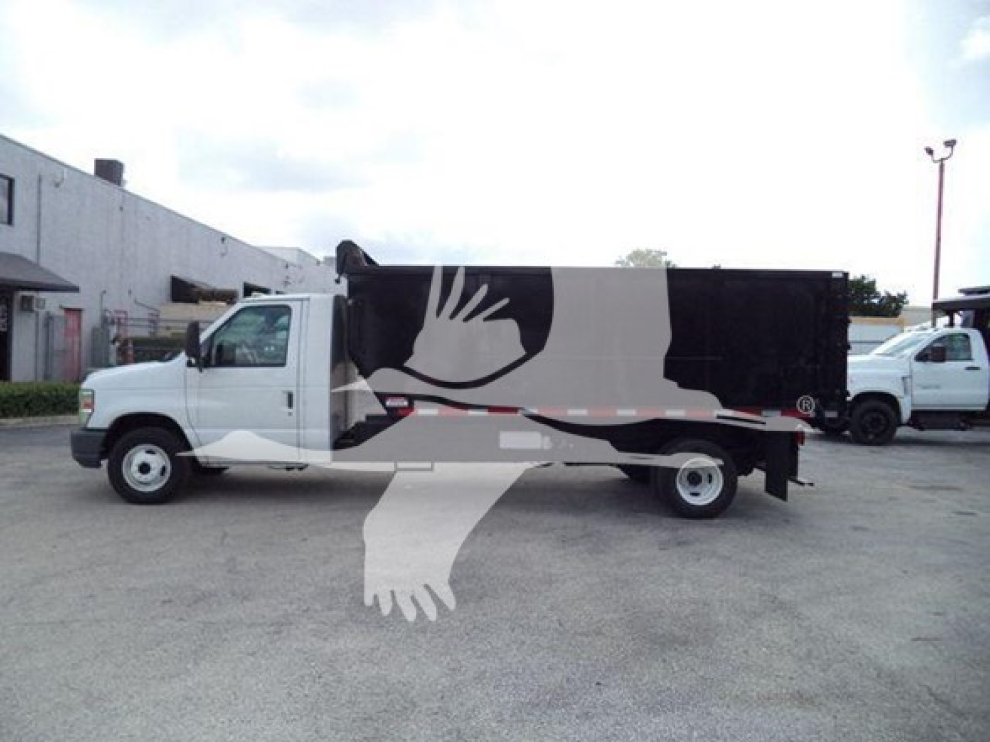 Ford E-450 dump truck side view showing cargo box and cab with white color, stock number T83803 and VIN 1FDXE4FS1BDA83803