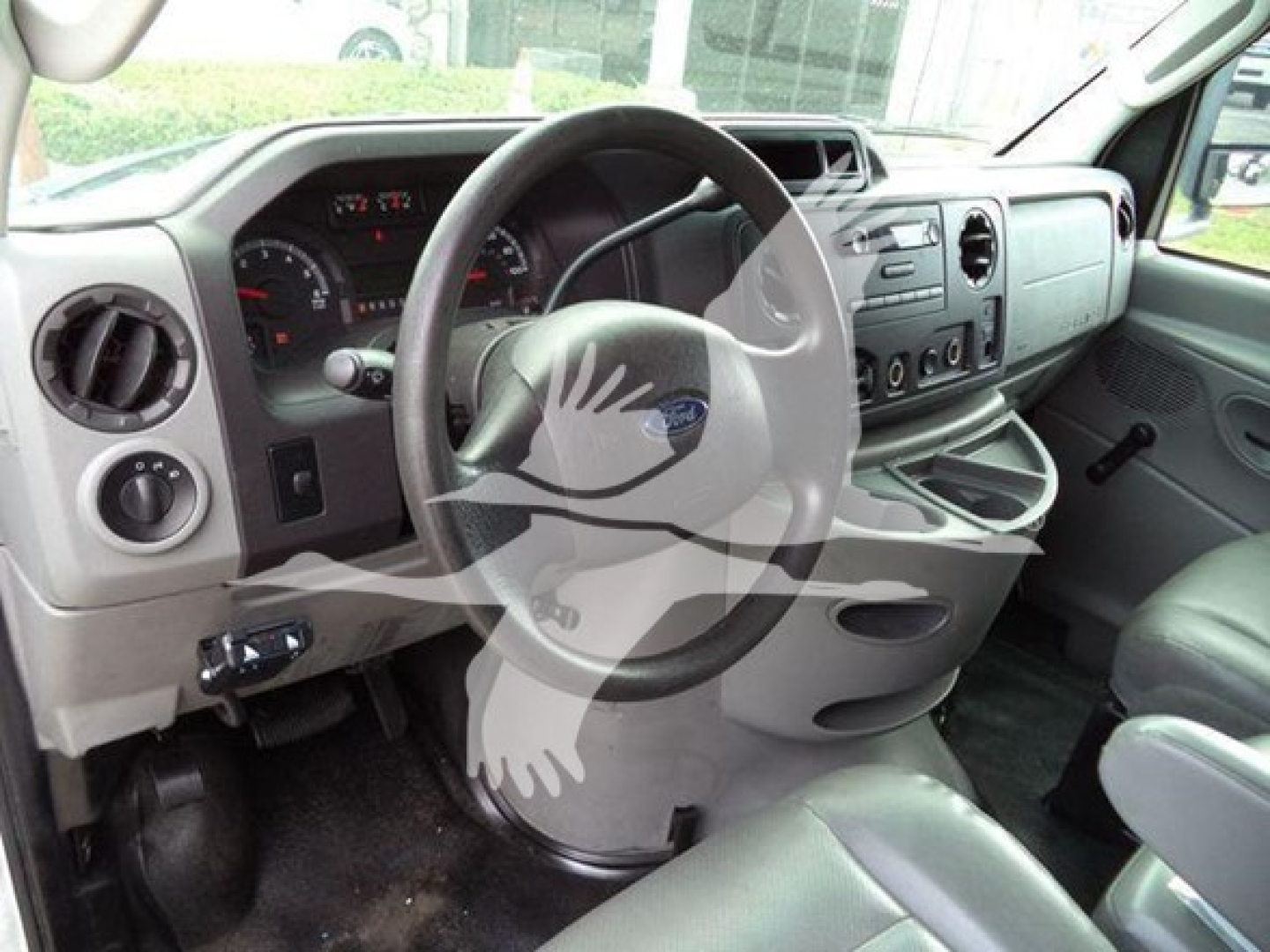 Ford E-Series cargo van interior with steering wheel and dashboard view.