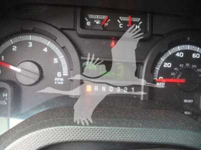 Ford E-450 dash cluster showing gear selector PRND321 and speedometer with RPM gauge; overlayed with faint watermark hands and feet image.