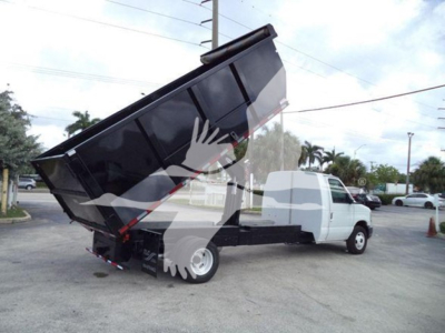 Ford E450 dump truck with raised dump bed showing side view and front cab.
