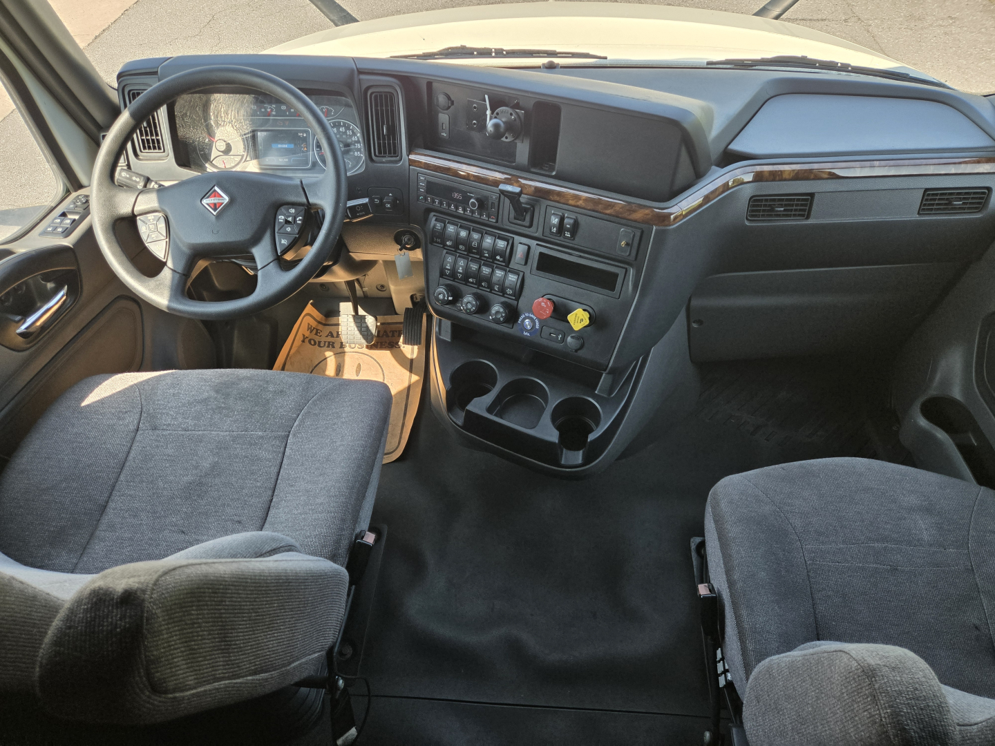 Truck cab interior of a 2021 International LT625 showing steering wheel, dashboard, controls, and seating.