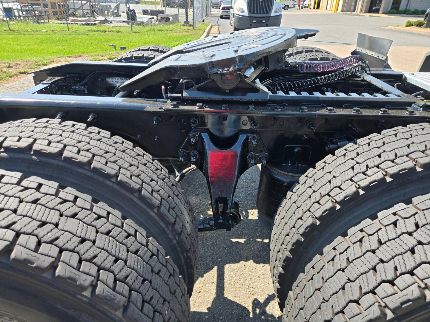 Tractor-trailer chassis and dual rear axles showing frame and fifth wheel base with tires and components visible.