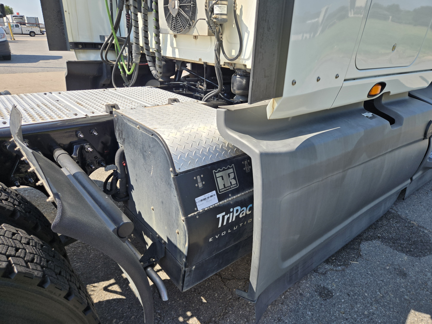 Truck cab area showing storage box with TiPaq EvoPower label and exposed drivetrain components.