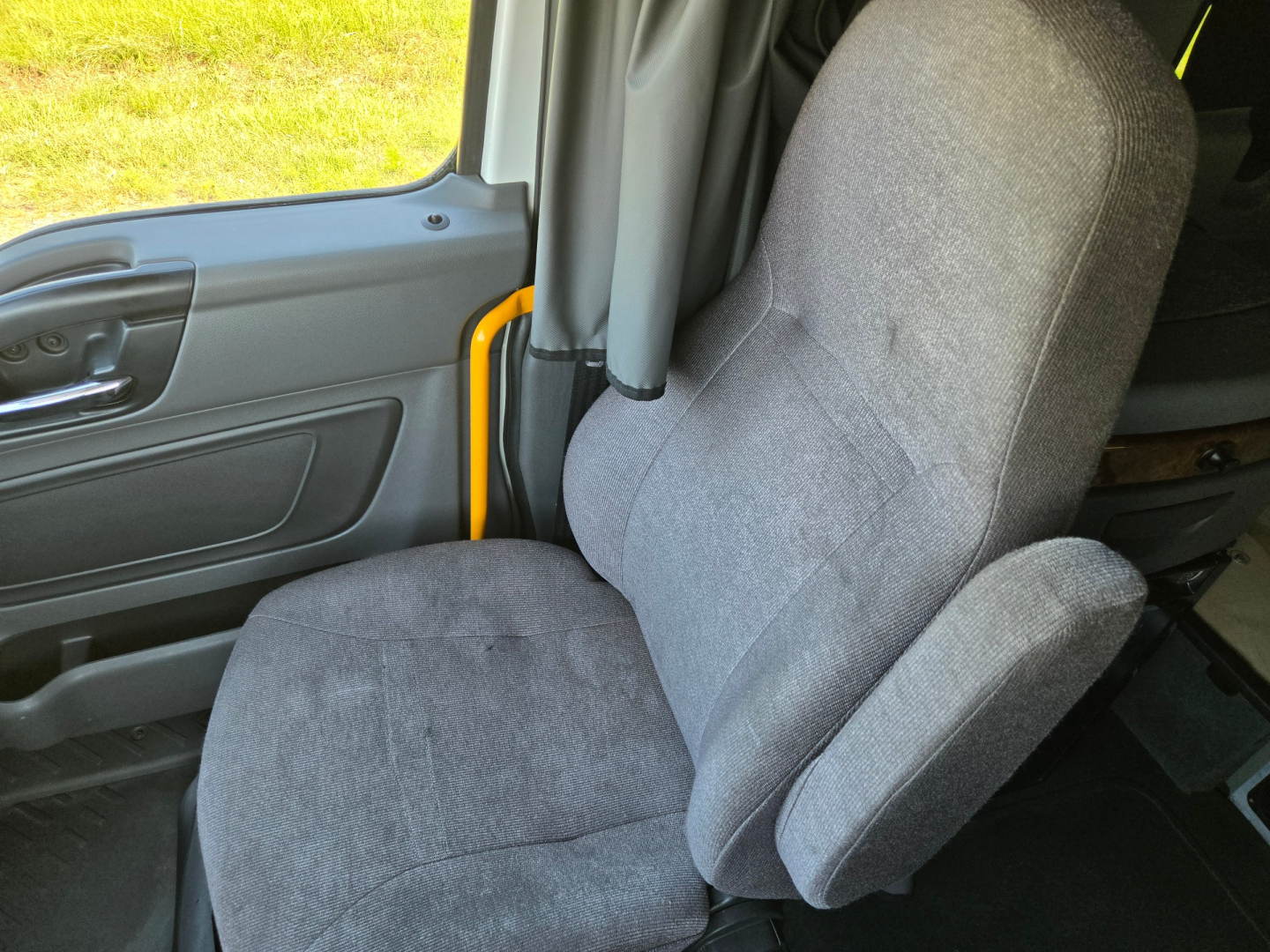 Truck cab interior with driver seat and door panel; no visible branding or text in image.