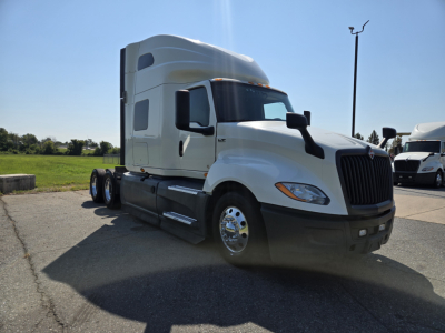 White 2021 International LT625 sleeper tractor side/front view showing cab, dual rear axles, and front bumper.