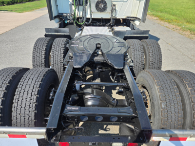 Truck chassis rear view showing fifth wheel and dual rear axles with six tires, International LT625, heavy-duty frame, drivetrain components visible.